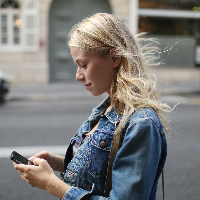 woman in street typing on mobile phone