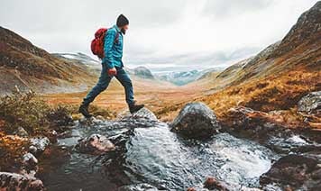 man walking over stream