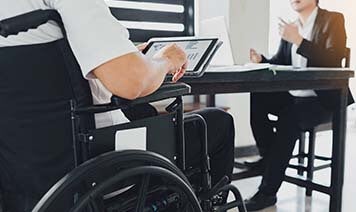 person in wheelchair on laptop