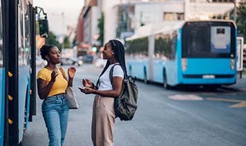 women talking outside bus