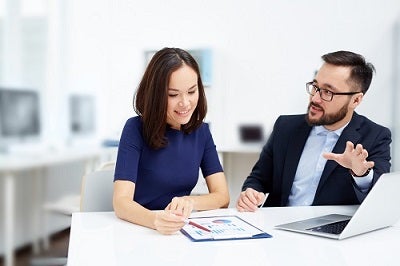 Two employees discussing document at meeting