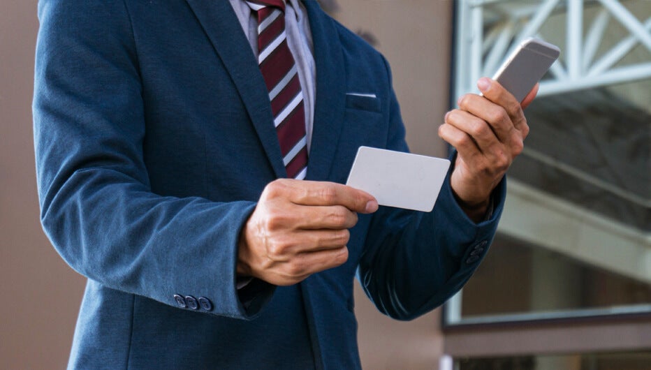 man holding phone and card