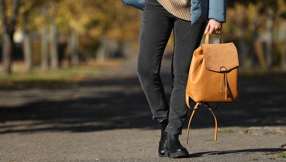 man walking while holding his bag