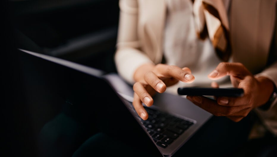 Women using phone and laptop